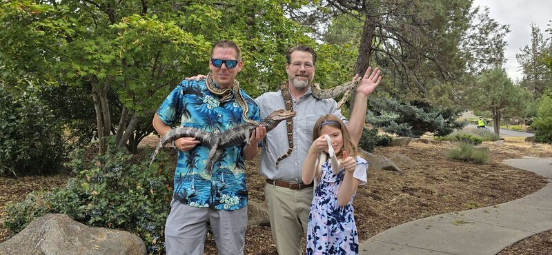Group photo with James, another adult, and a girl holding animals